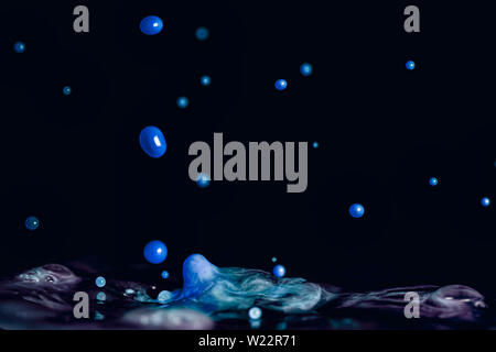 A colorful splash of vivid blue liquid isolated against a black background Stock Photo