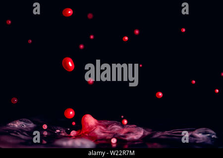 A colorful splash of vivid red liquid isolated against a black background Stock Photo