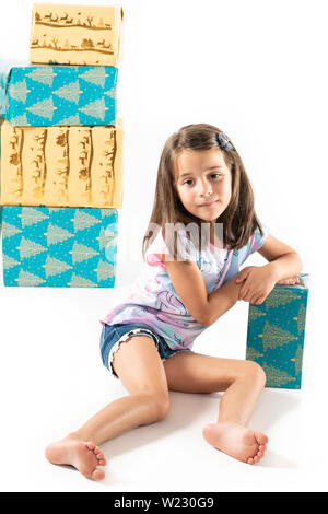 Cheerful young girl with stack of big gift boxes isolated on white with copy space. Stock Photo