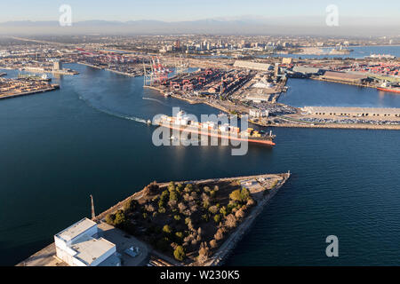Aerial view of container cargo ship leaving Long Beach Harbor in Los Angeles County California.