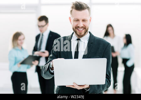 young entrepreneur uses a laptop while standing in the hallway of the office. people and technology Stock Photo
