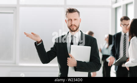businessman with a laptop holds a virtual object in his hand. photo with copy space Stock Photo