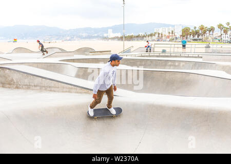 LOS ANGELES, CALIFORNIA, USA - May 11, 2019: Concrete ramps and palm trees at popular Venice beach skateboard park in Los Angeles, California Stock Photo