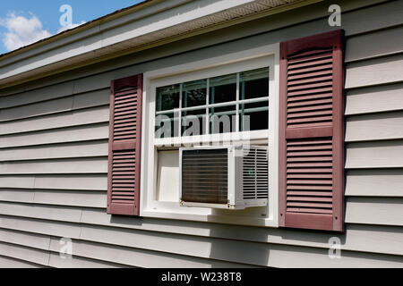 Air conditioner in house window on Summer day. Stock Photo