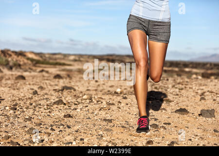 Summer trail running athlete runner legs lower body crop. Fitness woman jogging living an active lifestyle jogging on rocky path in mountain nature landscape. Shoes, knees, thighs weight loss concept. Stock Photo