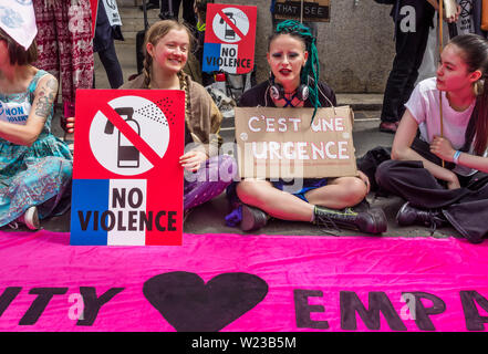 London, UK. 5th July 2019. Extinction Rebellion protest at the French Embassy in solidarity with XR France protesters who were brutally attacked by police during a peaceful protest on a Paris bridge. Police pepper-sprayed the faces of sitting protesters at close range causing burns, pulling sunglasses from one to spray directly into eyes, and injured some by dragging forcefully across the road. Credit: Peter Marshall/Alamy Live News Stock Photo