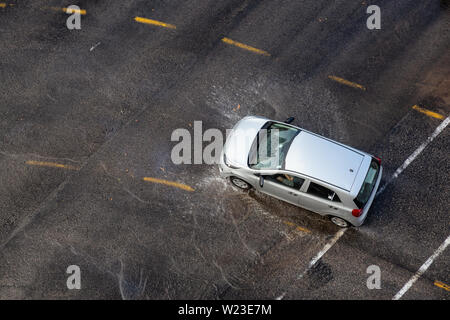 Havana, Cuba - May 29, 2019: Aerial view from above of an Old Car driving on the wet road after a rain pour. Stock Photo