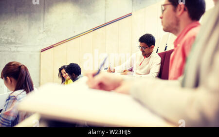 group of students with notebooks in lecture hall Stock Photo