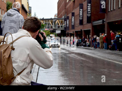 Man taking photos with camera of American cars cruising in Västerås city during Summer Meet - one of the biggest carshows in Europe Stock Photo