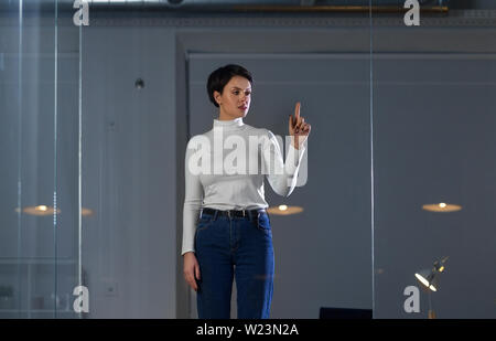 businesswoman using glass wall at night office Stock Photo
