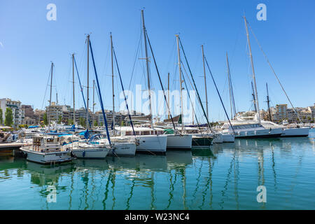 April 29, 2019. Marina Zeas in Piraeus, Greece. Moored yachts are ready for cruise. Reflection of boats, blue calm sea, city and sky background. Stock Photo