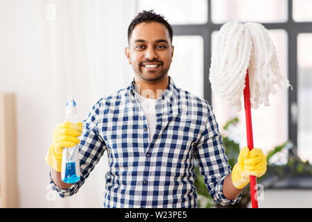 indian man with mop and detergent cleaning at home