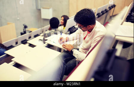 group of students with notebooks in lecture hall Stock Photo