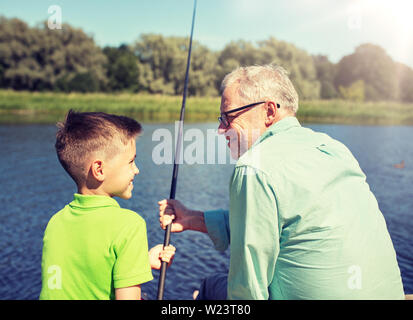 grandfather and grandson fishing on river berth Stock Photo