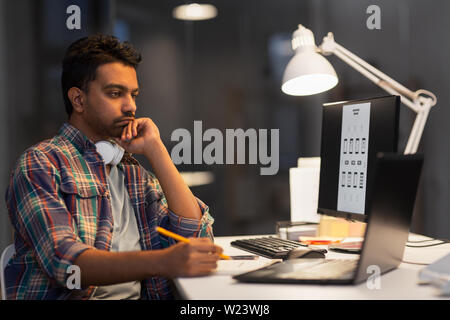creative man with laptop working at night office Stock Photo