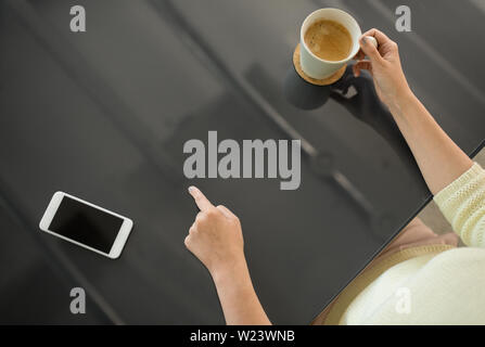 woman with coffee using black interactive panel Stock Photo