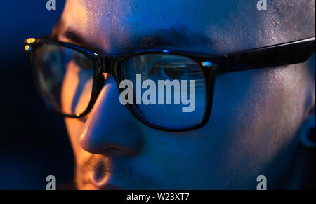 close up of hacker in glasses looking at screen Stock Photo
