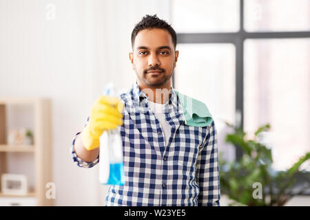smiling indian man with detergent cleaning at home