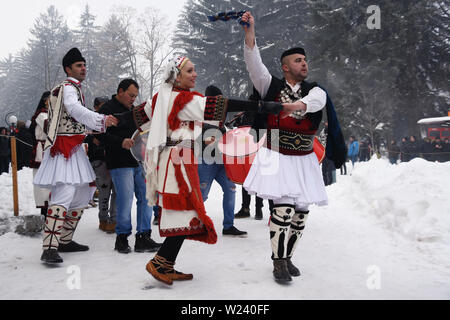 Razlog, Bulgaria - January 12, 2019: People in Bulgarian folk costumes dancing on the snowy streets of Razlog during Starchevata folk festival Stock Photo