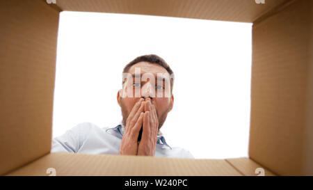 shocked man looking into open parcel box Stock Photo