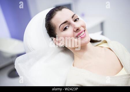 Portrait of young woman lying on couch in clinic. Stock Photo
