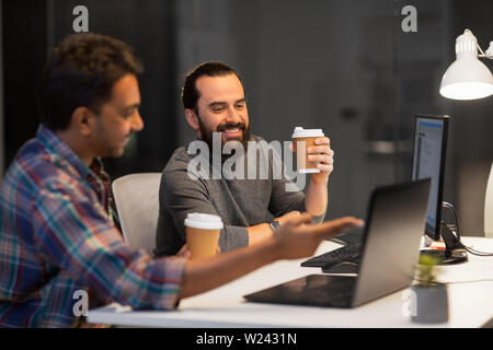 creative team drinking coffee at night office Stock Photo