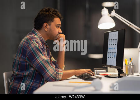creative man with computer working at night office Stock Photo