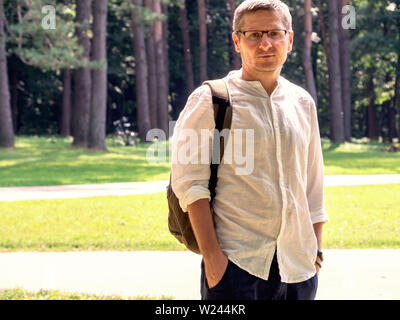 Sad caucasian 40 years man in the glasses, white shirt, outdor portrait, copy space Stock Photo