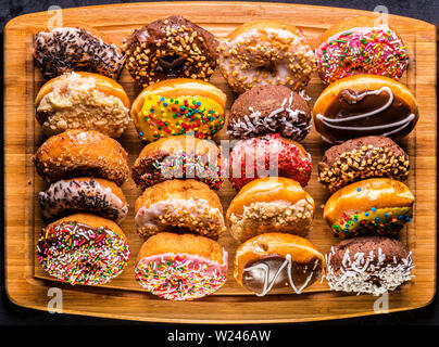 assorted donuts on wooden cutting board Stock Photo