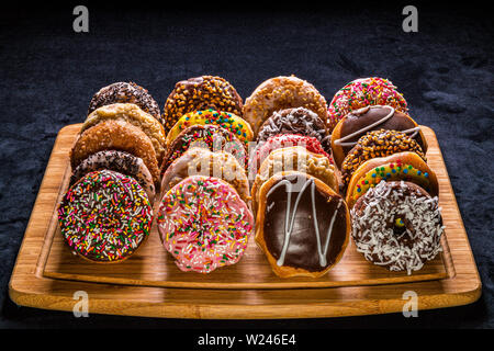 assorted donuts on wooden cutting board Stock Photo