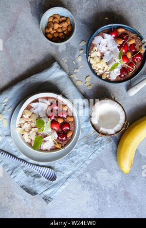 Healthy cherry coconut smoothie bowl with banana and almonds Stock Photo