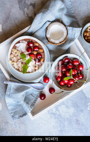 Healthy cherry coconut smoothie bowl with banana and almonds Stock Photo