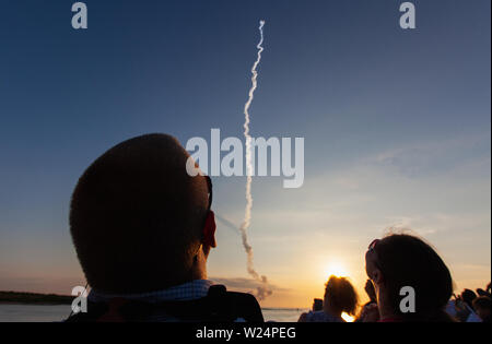 Crowds of spectators gather on a pier at Jetty Park to watch the NASA Orion Launch Abort System successfully launch atop a Northrop Grumman rocket booster from Launch Pad 46 at Cape Canaveral Air Force Station July 2, 2019 in Cape Canaveral, Florida. The flight test proved that the abort system can pull crew to safety in the unlikely event of an emergency during ascent opening the way to a launch of the new Orion launch system. Stock Photo