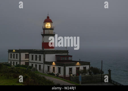 Cape Silleiro lighthouse at dusk on a rainy afternoon. Located in Baiona, Spain Stock Photo