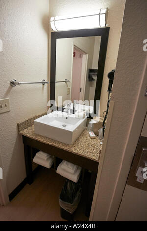 small sink and mirror in small bathroom in a cheap hotel room usa Stock Photo