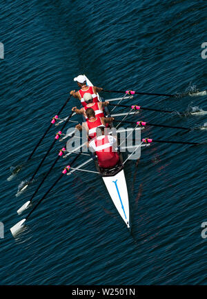 Four Male Rowers In A Quad Racing Boat With Synchronous Oar Stroke Stock Photo