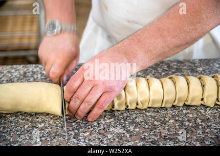 The production of French baguettes is a bakers art. You need to knead the dough properly to get an airy crispy baguette. A professional baker by hand Stock Photo