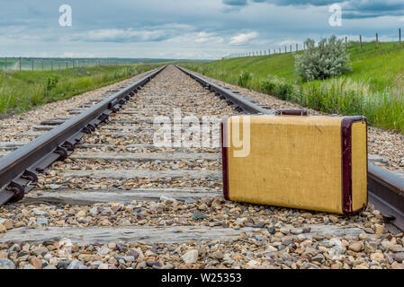 Vintage suitcase in the middle of railroad tracks on the prairies Stock Photo