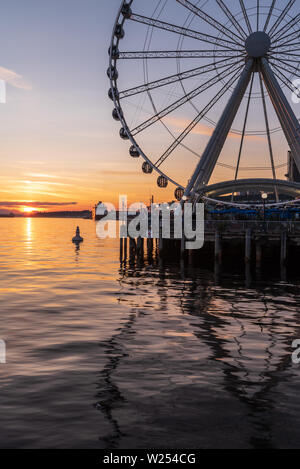 The Seattle Great Wheel is a Ferris wheel on the waterfront at Pier 57, overhanging Elliot Bay, with a great view of Puget Sound and the summer sunset Stock Photo