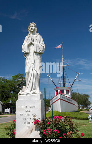Morgan City, Louisiana - Our Lady Star of the Sea statue in front of the Spirit of Morgan City shrimp trawler on the town's main street. Shrimping is Stock Photo