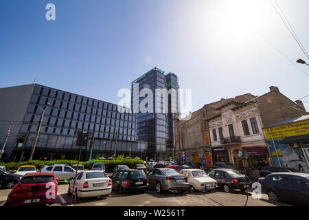 Bucharest, Romania - July 07, 2019: A modern high-rise building, called The Mark Tower, in contrast to some old buildings located on a street in Bucha Stock Photo