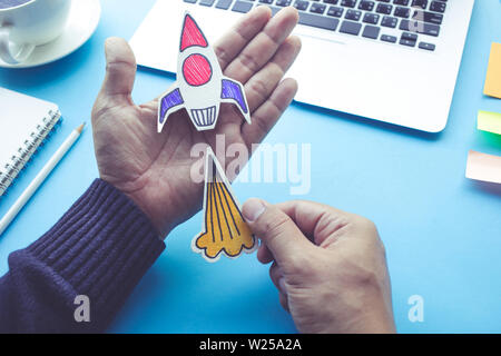 Start up concepts with rocket in male hand on desk table.Investment,success ideas Stock Photo