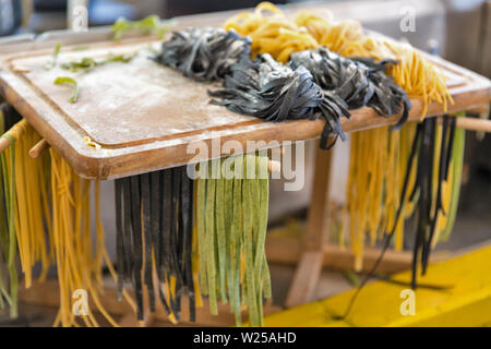Homemade egg noodles, noddles with cuttlefish and spinach on a wooden cutting board closeup Stock Photo