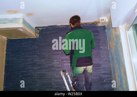 Ceramic tiles. Tilers of ceramic tiles glued to the wall Stock Photo