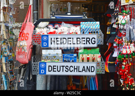 Tourist shop booth with different souvenirs related to the city of Heidelberg in Germany with license plate, plush toy bears, bags, Stock Photo