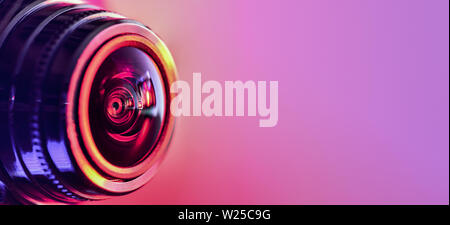 Side view of the camera with red-purple backlight. Horizontal photography. Banner Stock Photo