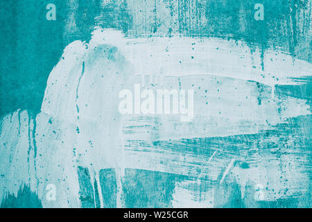 Drips of white paint on the turquoise wall. Painted dirty concrete wall. Smeared green wall in whitewash, stucco, plastering, stained plaster. Abstrac Stock Photo