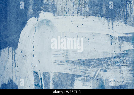 Smeared white paint stains on the blue wall. Drips of white paint on the blue canvas. Abstract pattern of spotted white stucco. Painted dirty concrete Stock Photo