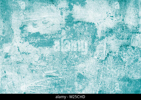 Turquoise shabby concrete wall with flaky plaster. Torn rough old texture. Vintage, cracked distressed background. Abstract green pattern. Virid paint Stock Photo