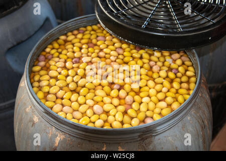 Olives factory. Olives in metal barrels in an interior plant for the production of olive oil on Cran Canaria. Concept of nature and healthy food. Stock Photo